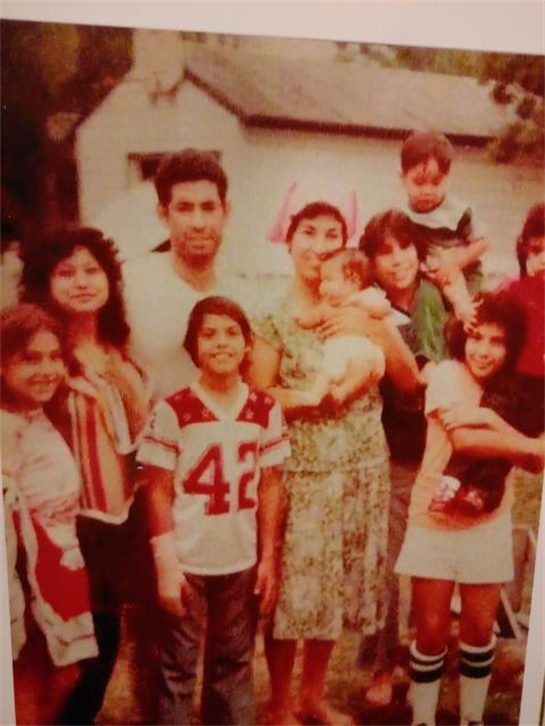 A lively family gathering featuring multiple adults and children in a backyard.