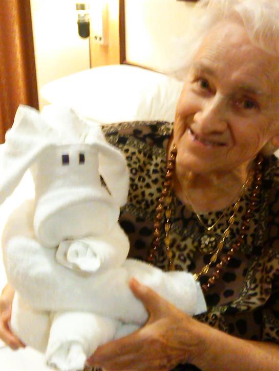 An elderly woman beams with joy while cradling a charming stuffed toy, showcasing her delight.
