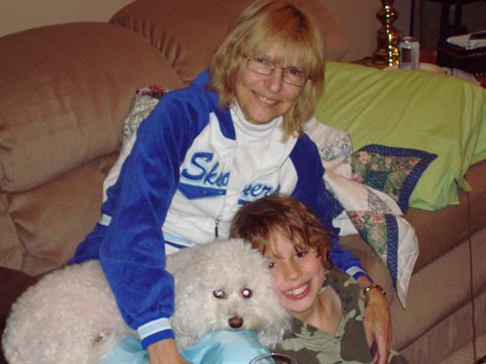 Family enjoys quality time together on couch, sharing warmth and laughter with their pet.