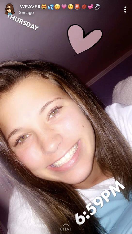 A young woman is smiling brightly, capturing a joyful moment in a relaxed atmosphere.