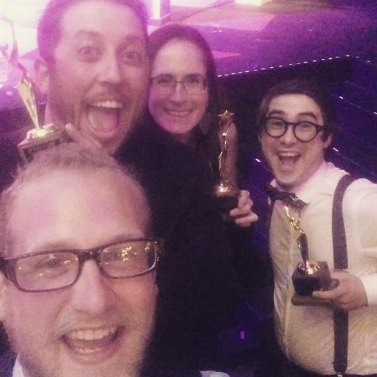 Friends joyfully celebrate their recent awards in a lively, colorful setting filled with excitement.