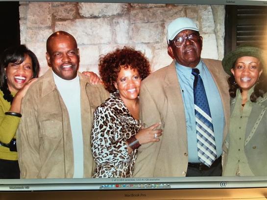 Four family members showcase their love for each other with warm smiles and casual attire.