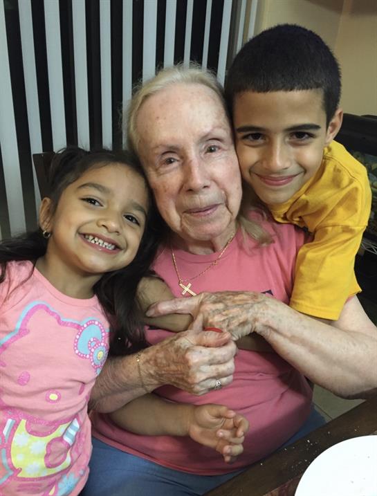 Two children share joyful moments with their grandmother, celebrating family bonds and love.