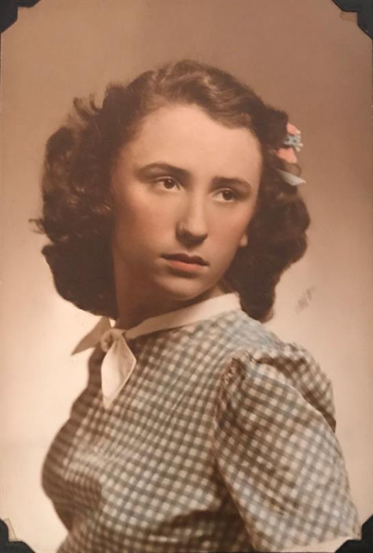 A girl in a checked dress and floral hair piece gazes sideways, embodying nostalgia.