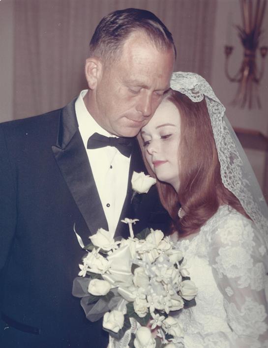 Bride and groom embrace warmly, showcasing love and joy in a heartfelt wedding celebration.