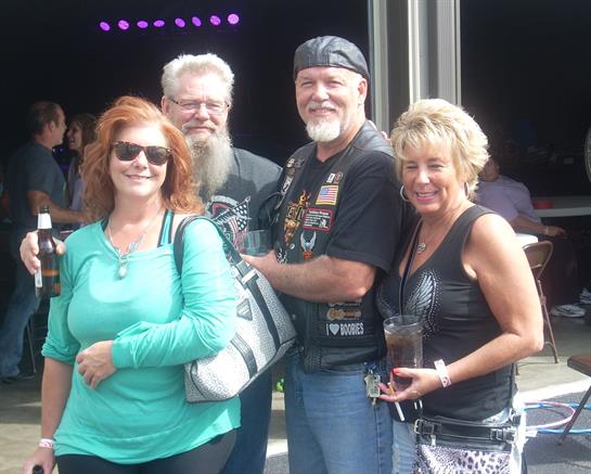 Four friends smile in casual clothes, enjoying the festive atmosphere together.