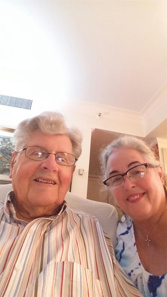 Couple enjoys a warm moment together in a comfortable living space while smiling happily.