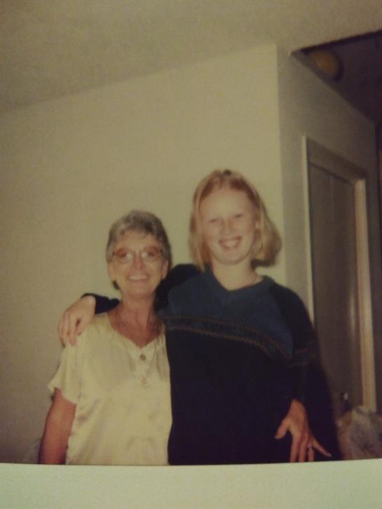 Two women share a warm embrace and smiles in a relaxed living space filled with love.