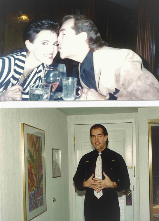 A couple playfully drinks at a bar while a man stands formally in a hallway.