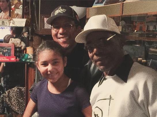 Three people share joyful moments together in a cozy indoor setting with warm smiles.