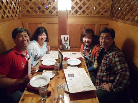Four friends share laughter and conversation while dining at a restaurant on a cozy evening.