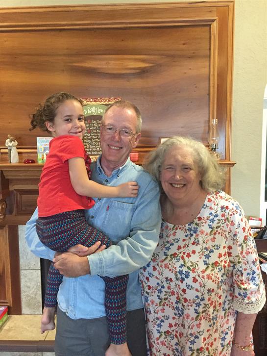 A joyful family gathers in a warm living room, sharing smiles and laughter during a sunny day.