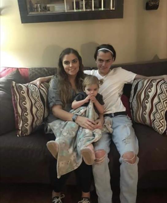 Three family members enjoy a relaxed moment on a couch, showcasing connection and warmth.