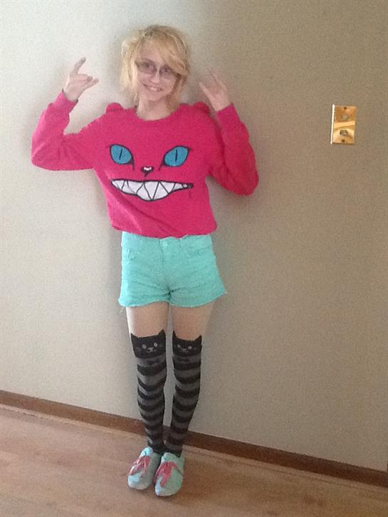 Person showcases a unique outfit featuring a bright sweater and playful accessories in a cozy room.