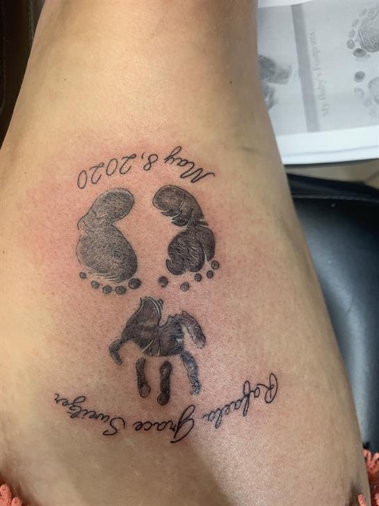 A detailed tattoo showcases baby footprints and a turtle, highlighting a significant date below.