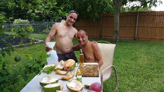 Friends celebrate together in a garden, grilling food and sharing drinks on a warm day.