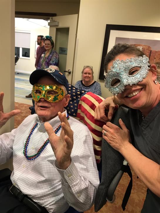 Participants celebrate joyfully, donning colorful masks at a lively community event.