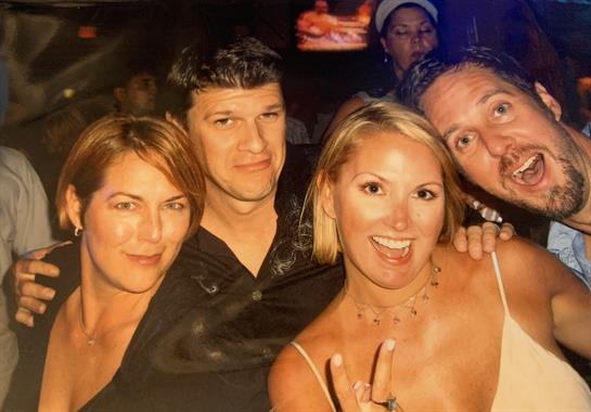Four friends posing happily together at a club, capturing a moment of joy and celebration.