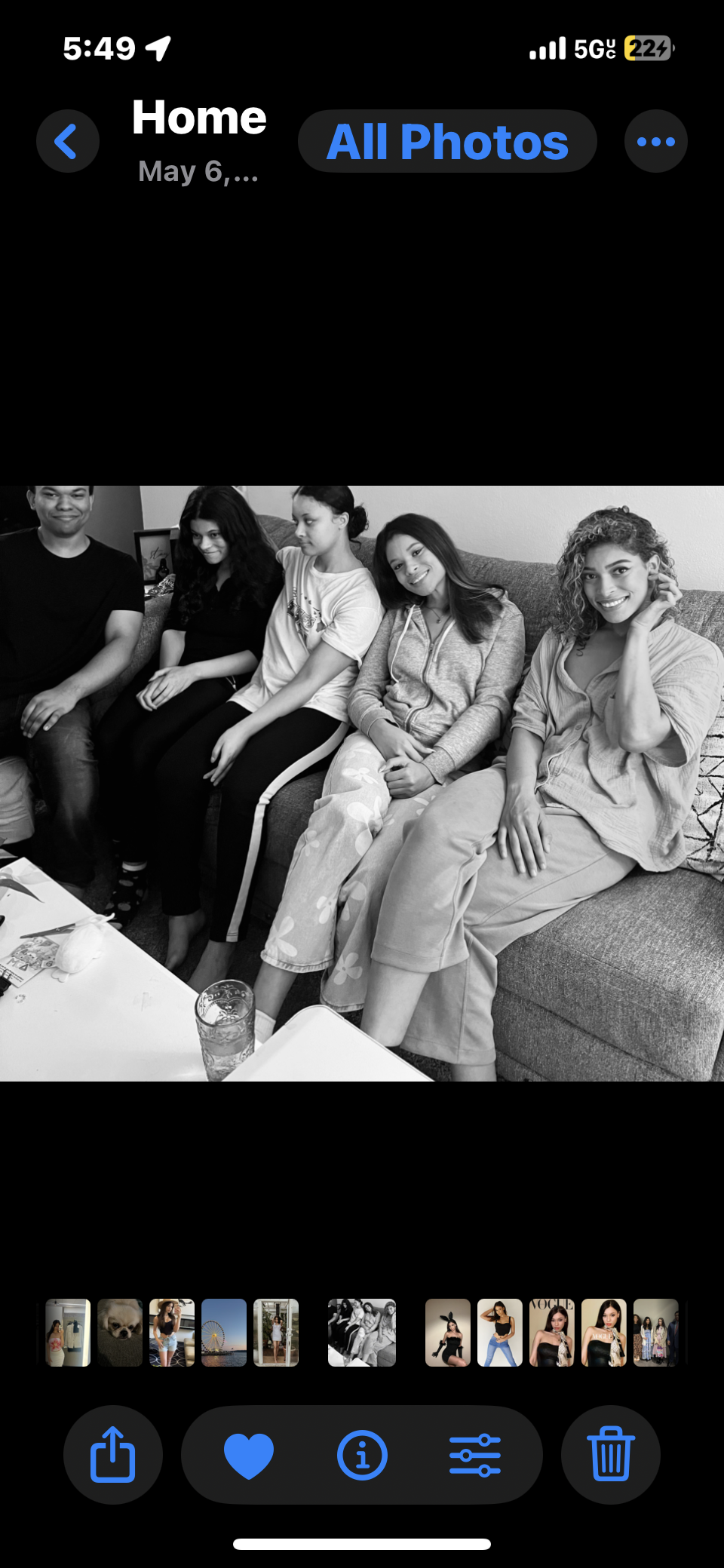 Group of friends sit together on a couch sharing laughter and enjoying a casual moment at home.