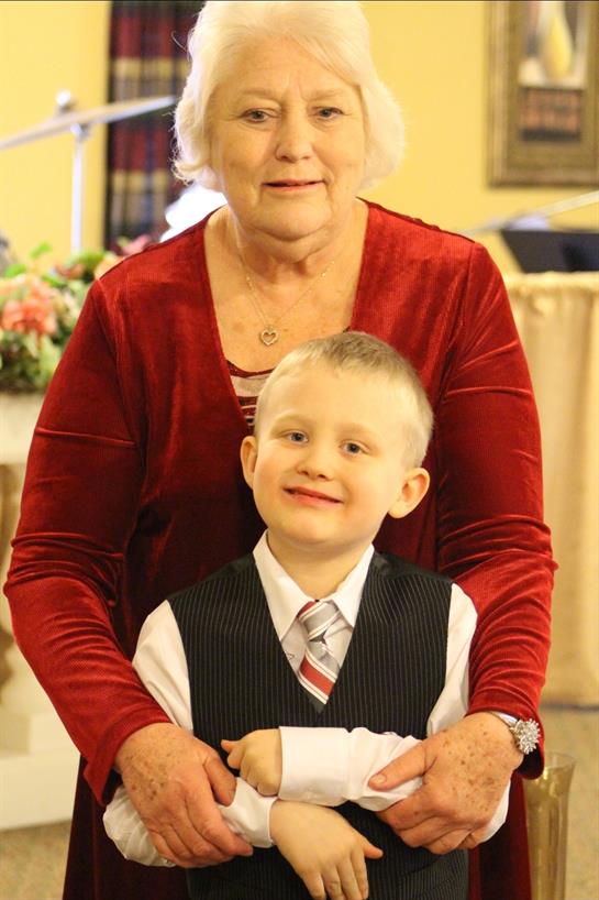 Grandmother and her grandson share a joyful moment during a family event in a warm environment.