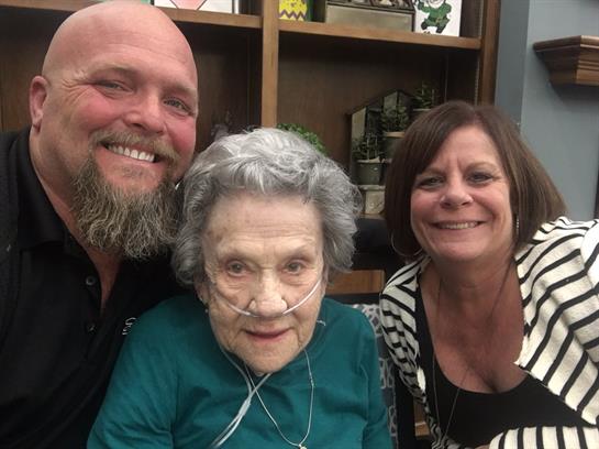 Family members enjoy a joyful reunion with their elderly relative at a care home during autumn.
