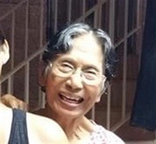 An elderly woman shares a moment of joy with a family member at home during the evening.