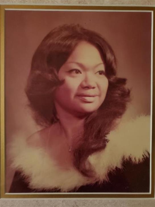 A graceful woman in fur-collared attire exudes elegance with her long, flowing hair.