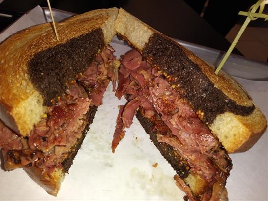 Heaping portions of roasted meat are sandwiched between crispy toasted bread.