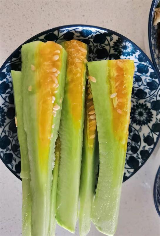 Yellow cucumber slices display their vibrant color on a patterned blue plate, ready to eat.