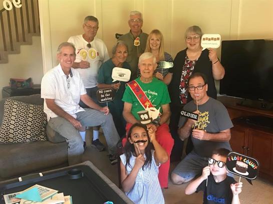 Group of family members enjoying a fun gathering with playful props and smiles indoors