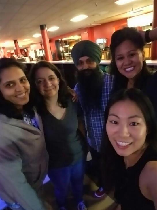 Five friends gather closely, smiling and enjoying each other's company in a lively setting.