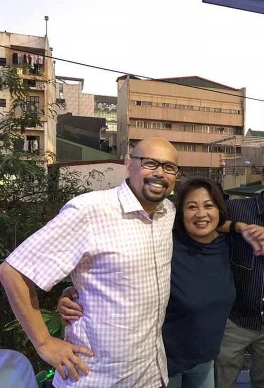 Two friends share smiles while standing outdoors in Nairobi, surrounded by urban buildings.