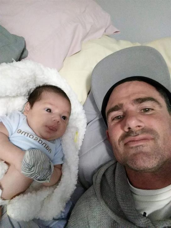 A father and his baby are sharing a joyful moment at home, showcasing their bond and happiness.