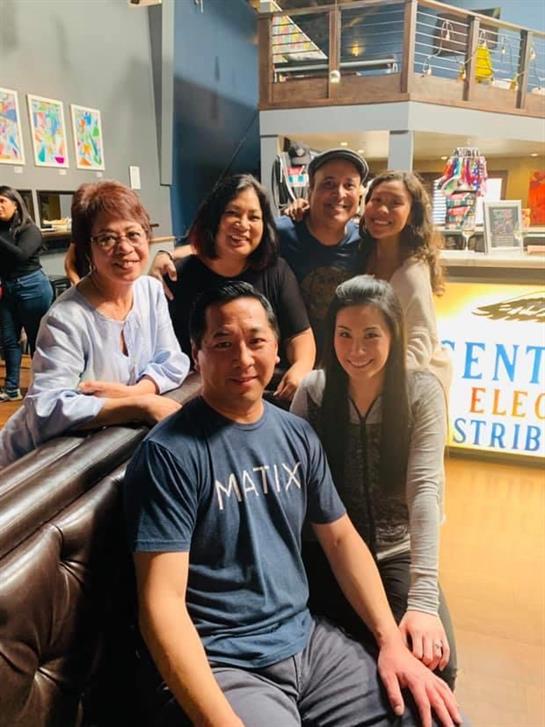 A group of friends smiles warmly while enjoying their time together in a vibrant community center.