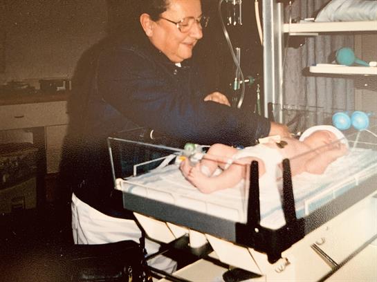 A nurse gently cares for a newborn in a hospital nursery, showcasing compassion and expertise.