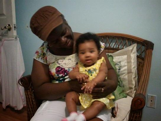 A grandmother lovingly holds her cheerful granddaughter in a cozy home setting, filled with warmth.