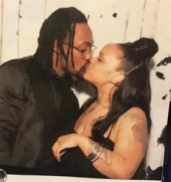 A couple is sharing a loving kiss at a festive indoor celebration surrounded by decorations.