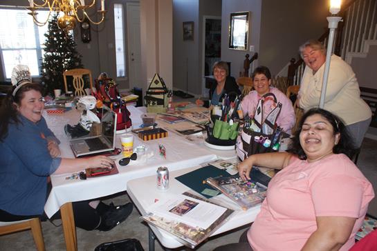Friends gather around a table filled with crafting supplies, sharing laughter and creativity.