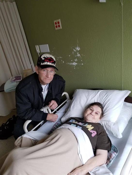 A visitor provides companionship to a patient in a hospital bed, highlighting their bond.
