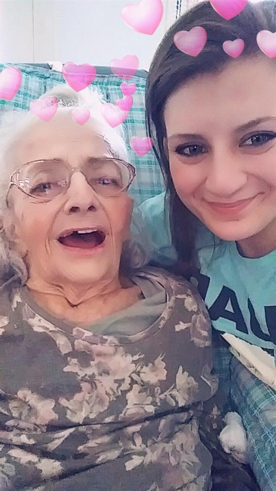 Grandmother and granddaughter smile together, enjoying a cheerful moment at home.