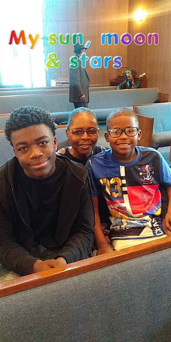 Three family members sit together smiling in a church, showing close bonds and happiness.