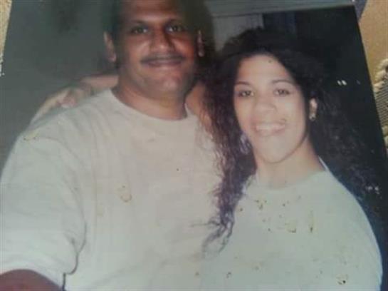 A couple smiles warmly while enjoying time together at a social event during the evening.