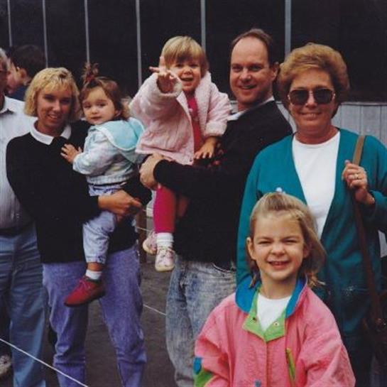 A group of adults and children gather for a fun day outdoors, smiling and posing for the camera.