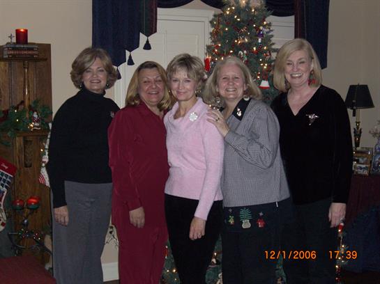 Group of friends poses together during a festive gathering in the living room with decorations.