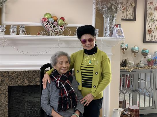 Friends share a warm moment in a beautifully decorated living room on a winter day.