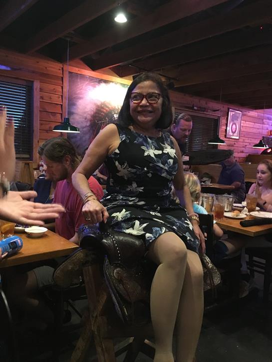 A joyful celebration takes place as a woman has fun with her family at a lively restaurant.