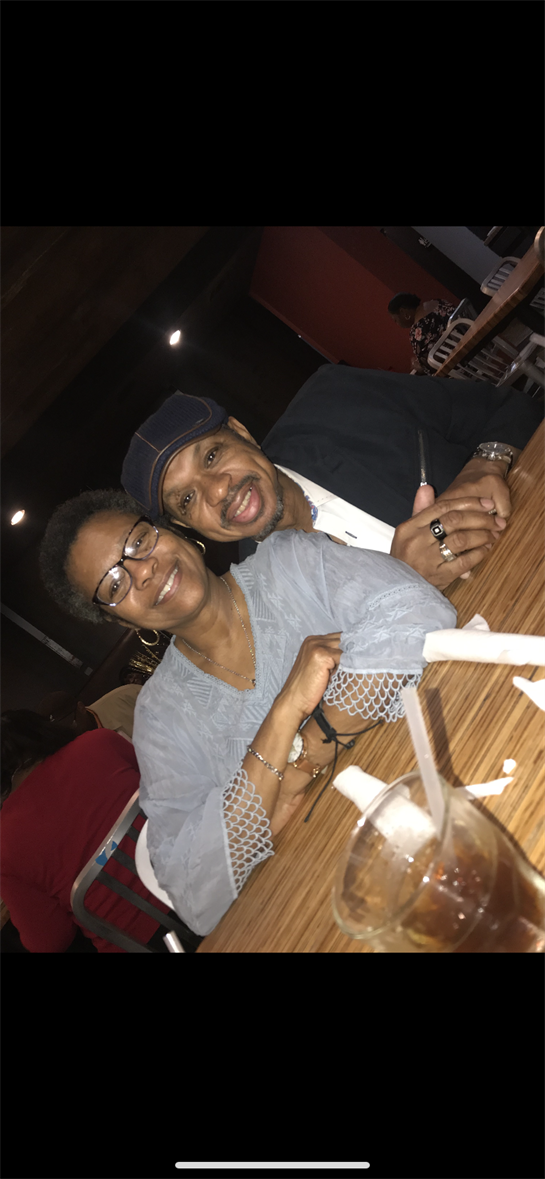 Smiling couple sharing a joyful moment at a restaurant with cozy lighting and vibrant surroundings.