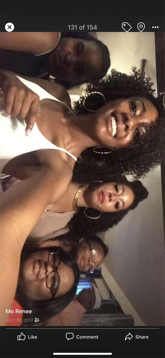 Friends smiling and posing happily together during a fun evening celebration indoors.