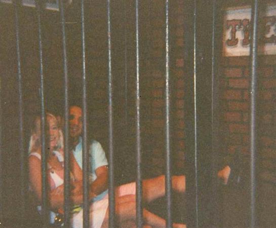 Two people sit closely together, sharing a moment in a cozy urban environment at night.