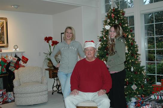 Gathered around a Christmas tree, a family shares smiles and festive cheer in their cozy home.
